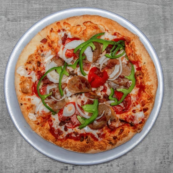 A whole pizza with green peppers, onions, red peppers, and sausage on a metal pan.